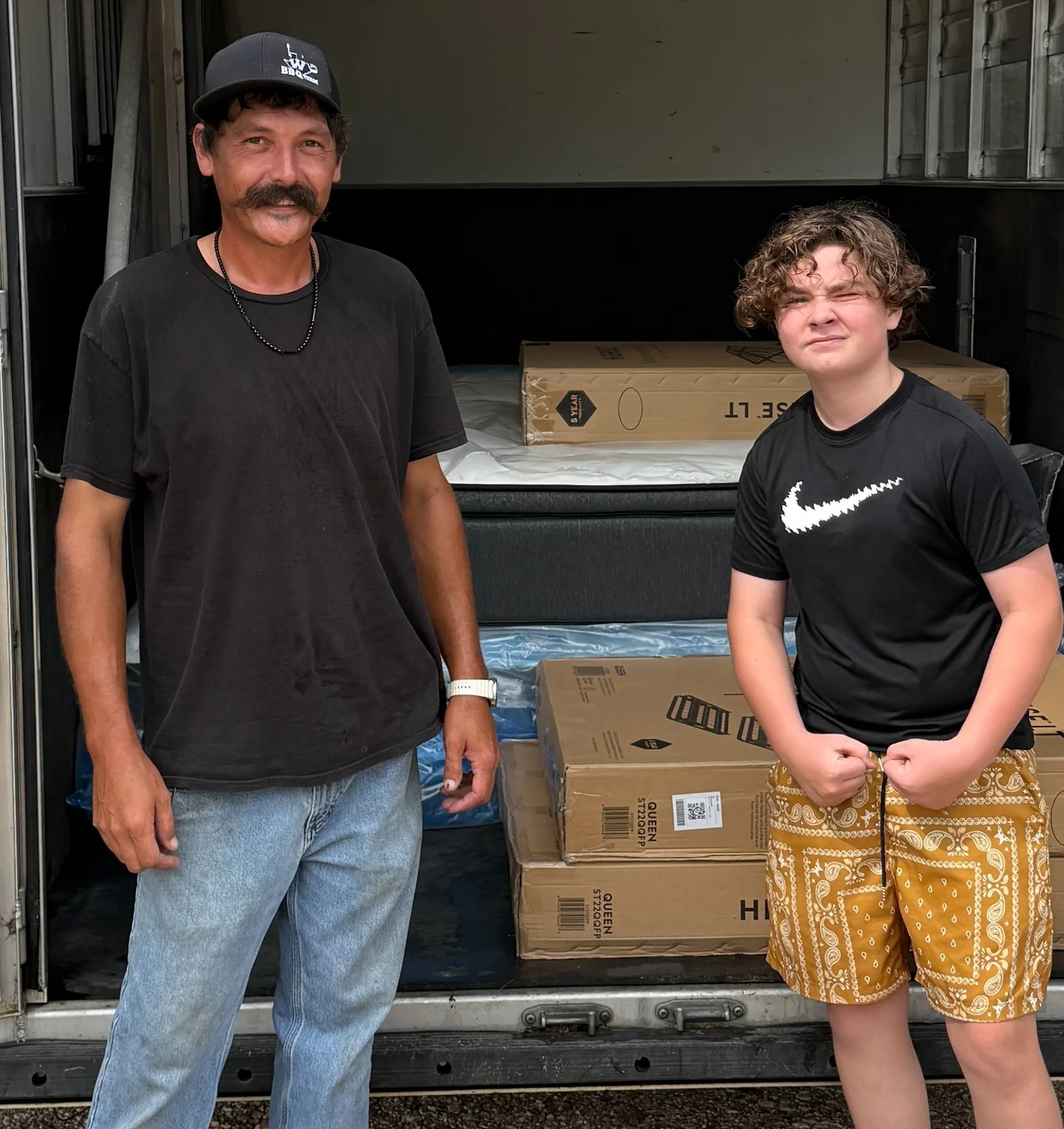 Customers standing with mattresses and bedding loaded for pickup